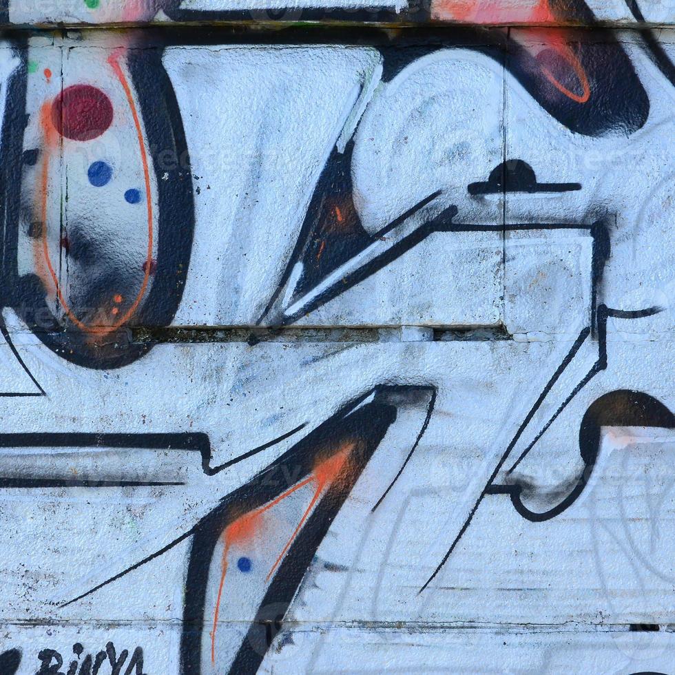 Fragment of graffiti drawings. The old wall decorated with paint stains in the style of street art culture. Colored background texture photo