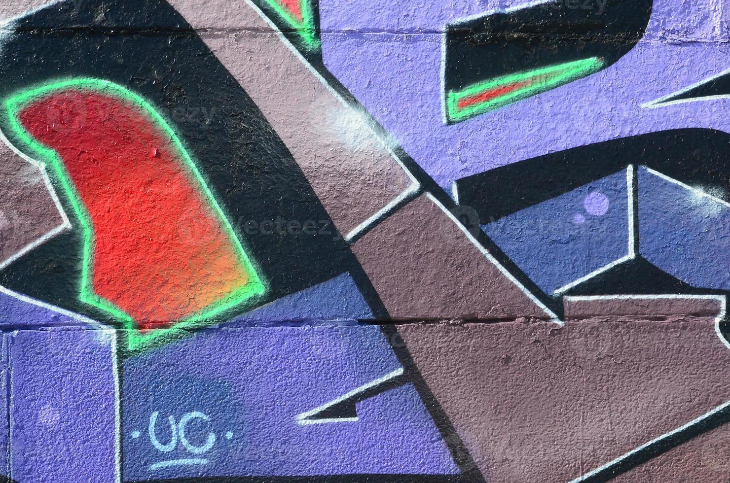 Fragment of graffiti drawings. The old wall decorated with paint stains in the style of street art culture. Colored background texture in purple tones photo