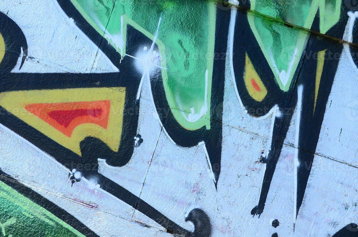 Fragment of graffiti drawings. The old wall decorated with paint stains in the style of street art culture. Colored background texture in green tones photo