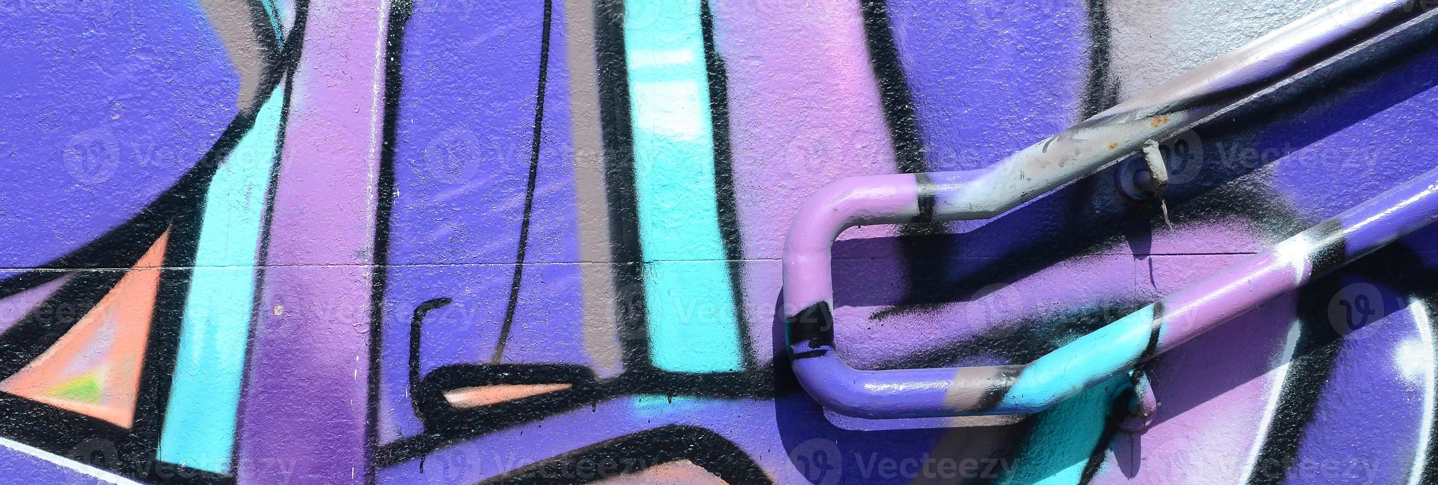 fragmento de dibujos de graffiti. la antigua muralla decorada con manchas de pintura al estilo de la cultura del arte callejero. textura de fondo coloreada en tonos morados foto