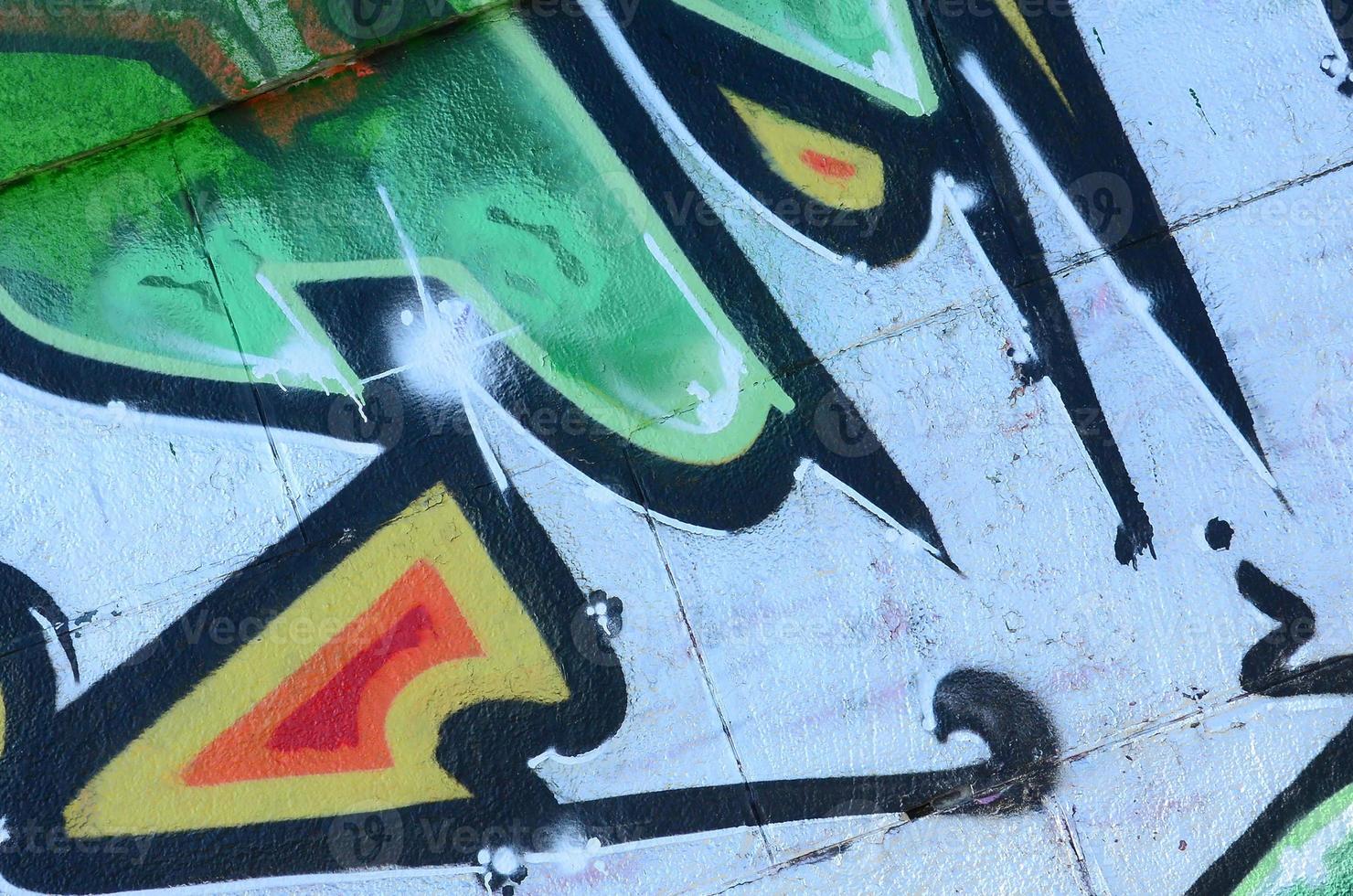 Fragment of graffiti drawings. The old wall decorated with paint stains in the style of street art culture. Colored background texture in green tones photo