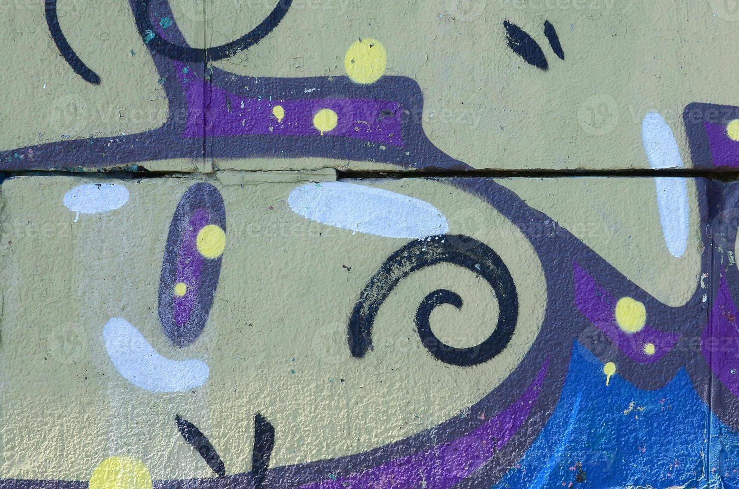 Fragment of graffiti drawings. The old wall decorated with paint stains in the style of street art culture. Colored background texture in warm tones photo