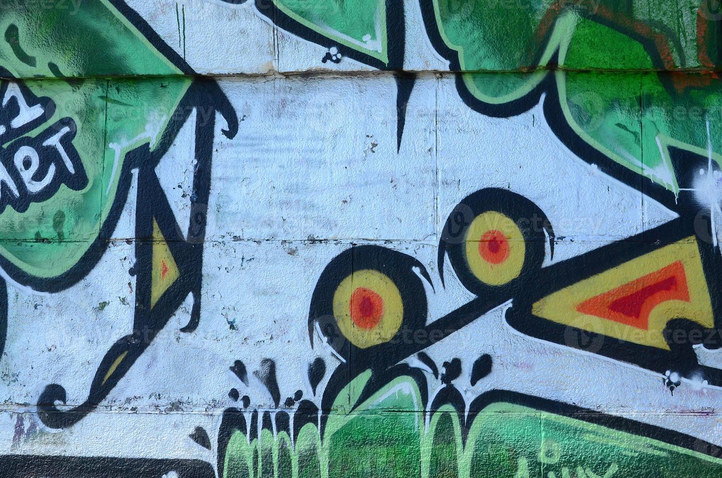 Fragment of graffiti drawings. The old wall decorated with paint stains in the style of street art culture. Colored background texture in green tones photo
