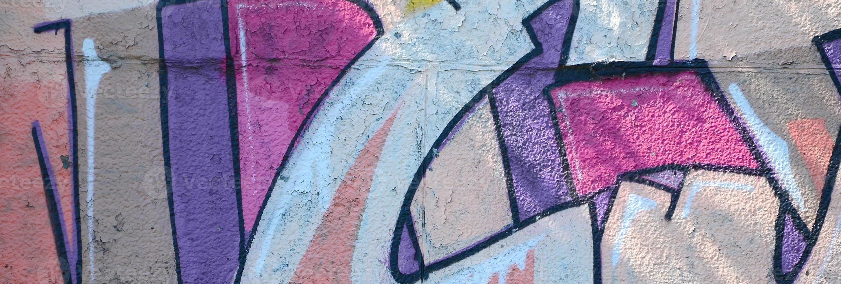Fragment of graffiti drawings. The old wall decorated with paint stains in the style of street art culture. Colored background texture in warm tones photo