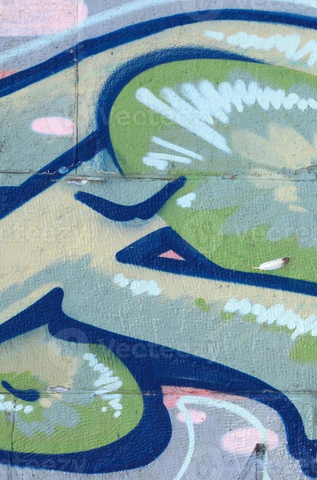 Fragment of graffiti drawings. The old wall decorated with paint stains in the style of street art culture. Colored background texture in green tones photo