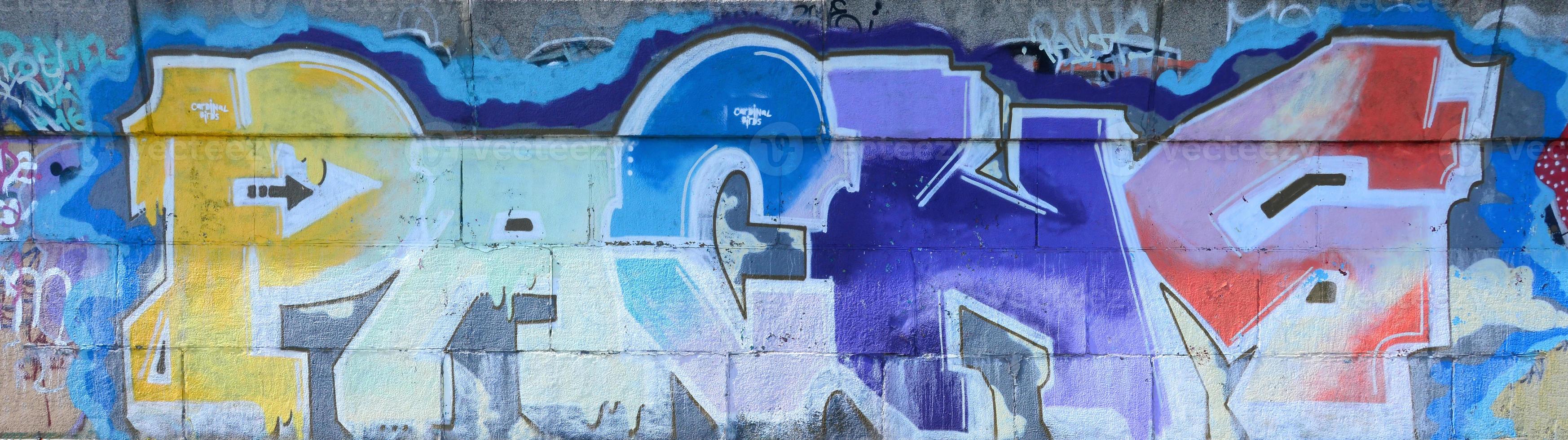 Fragment of graffiti drawings. The old wall decorated with paint stains in the style of street art culture. Multicolored background texture photo