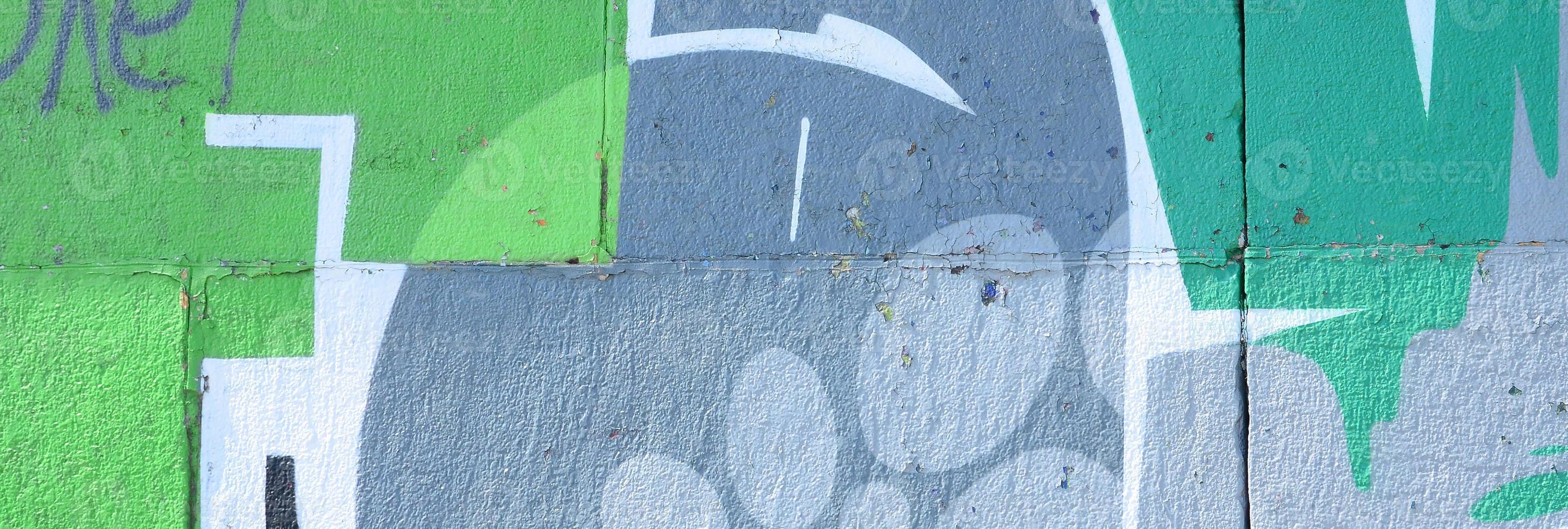 Fragment of graffiti drawings. The old wall decorated with paint stains in the style of street art culture. Colored background texture in green tones photo