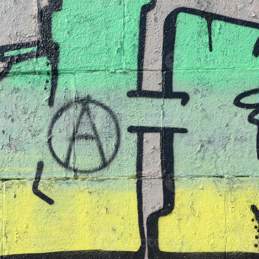 Fragment of graffiti drawings. The old wall decorated with paint stains in the style of street art culture. Colored background texture in green tones photo