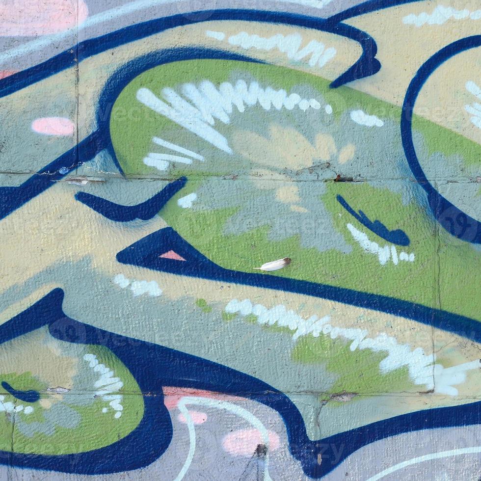Fragment of graffiti drawings. The old wall decorated with paint stains in the style of street art culture. Colored background texture in green tones photo