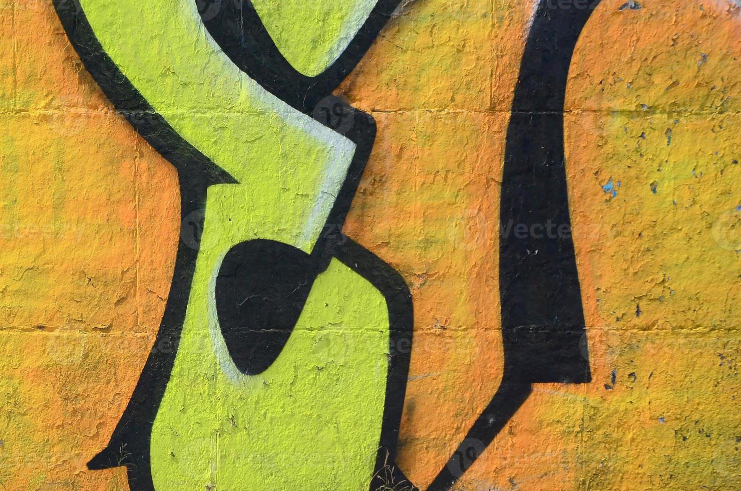 Fragment of graffiti drawings. The old wall decorated with paint stains in the style of street art culture. Colored background texture in warm tones photo