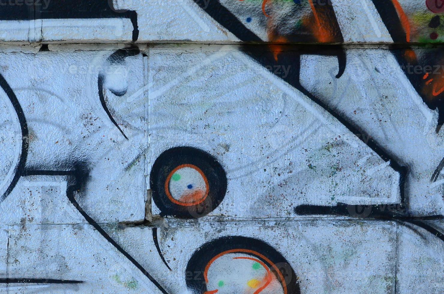 Fragment of graffiti drawings. The old wall decorated with paint stains in the style of street art culture. Colored background texture photo