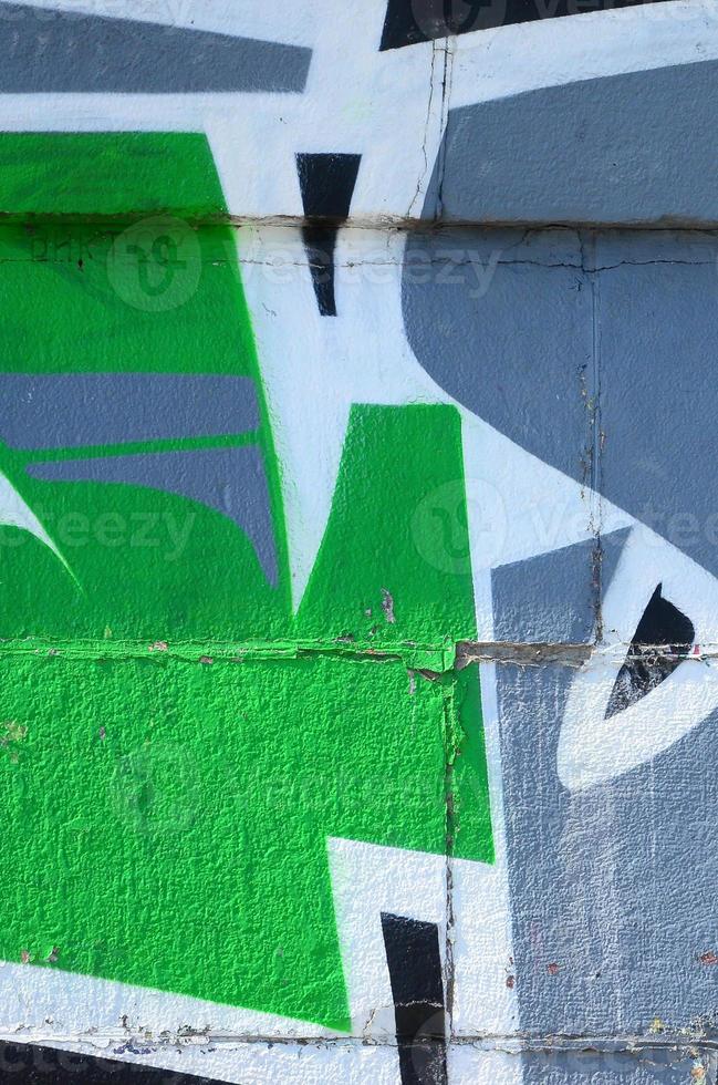 Fragment of graffiti drawings. The old wall decorated with paint stains in the style of street art culture. Colored background texture in green tones photo
