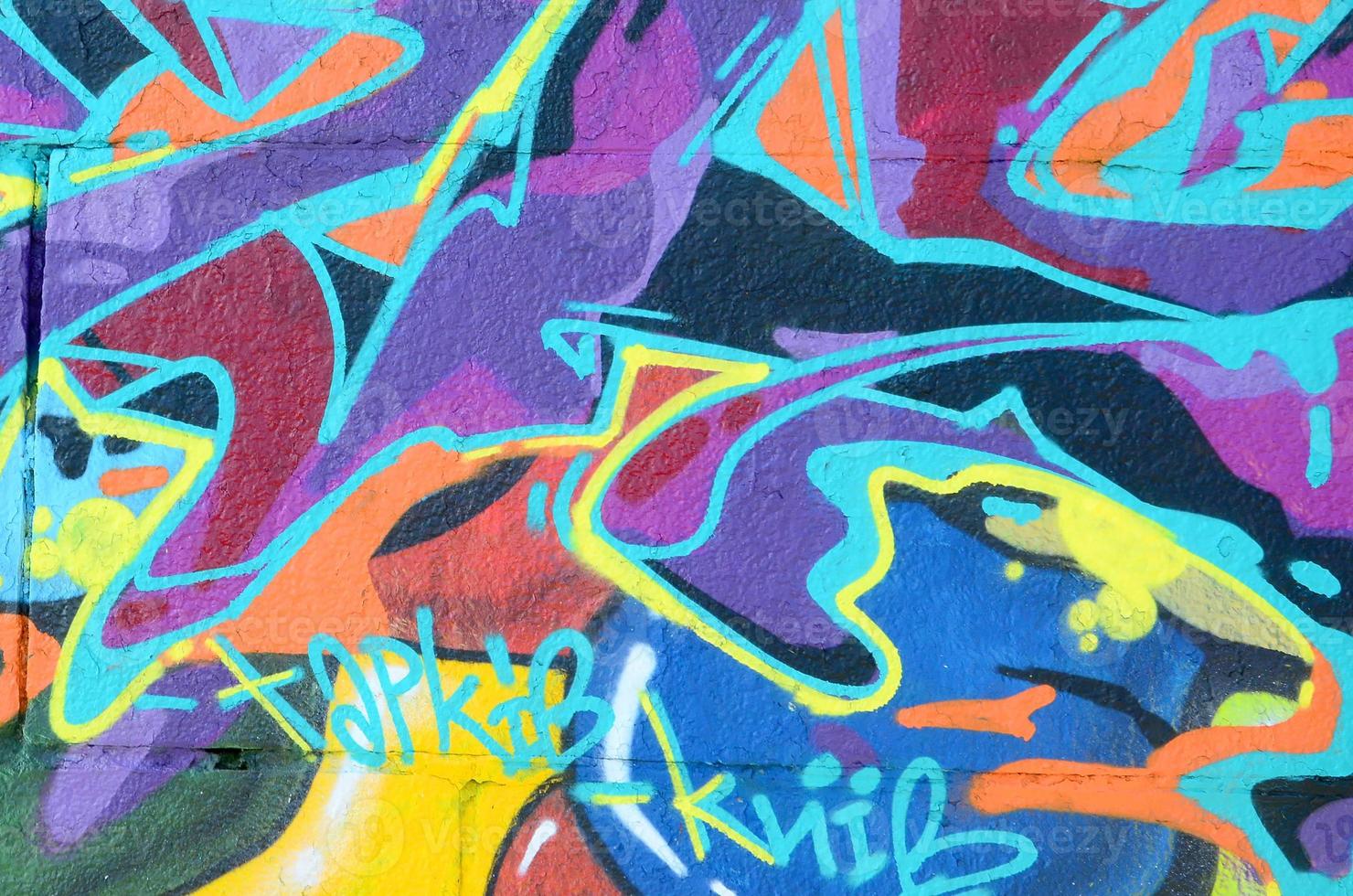 Fragment of graffiti drawings. The old wall decorated with paint stains in the style of street art culture. Multicolored background texture photo