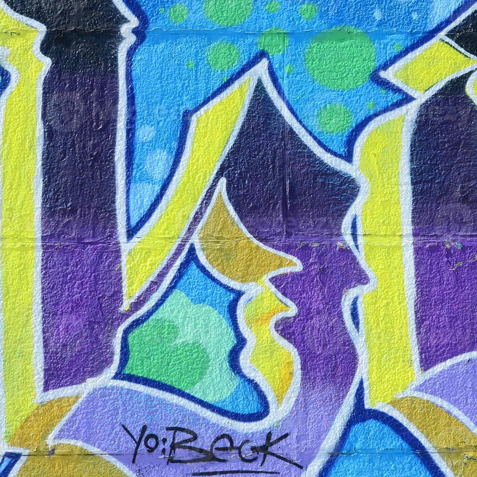 fragmento de dibujos de graffiti. la antigua muralla decorada con manchas de pintura al estilo de la cultura del arte callejero. textura de fondo coloreada en tonos fríos foto