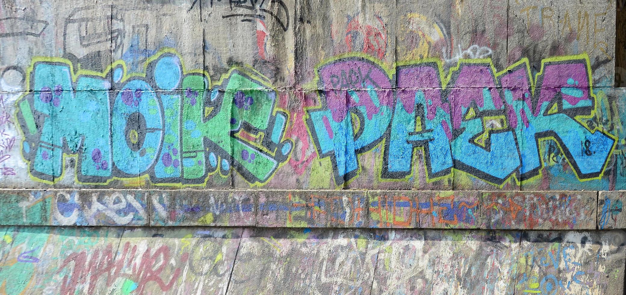 Fragment of graffiti drawings. The old wall decorated with paint stains in the style of street art culture. Colored background texture in cold tones photo