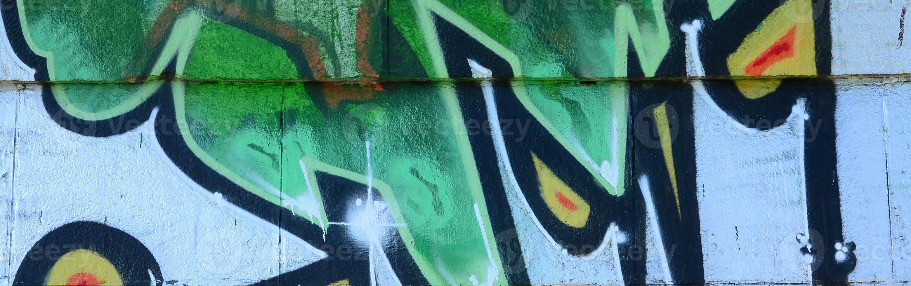 Fragment of graffiti drawings. The old wall decorated with paint stains in the style of street art culture. Colored background texture in green tones photo