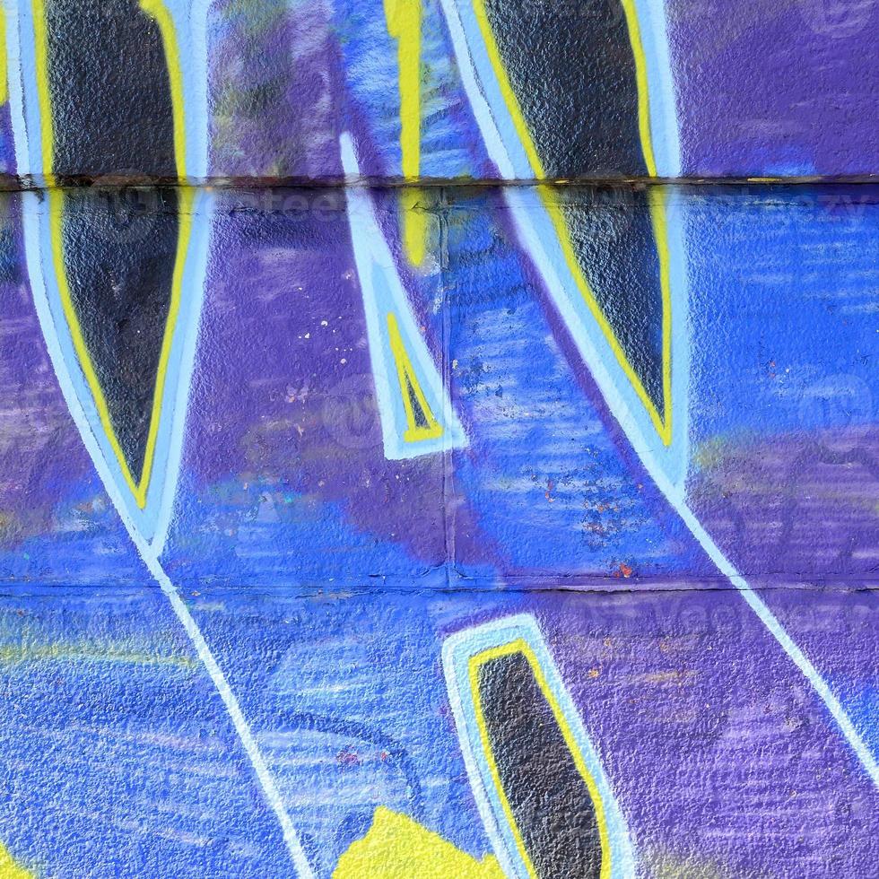 Fragment of graffiti drawings. The old wall decorated with paint stains in the style of street art culture. Colored background texture in cold tones photo