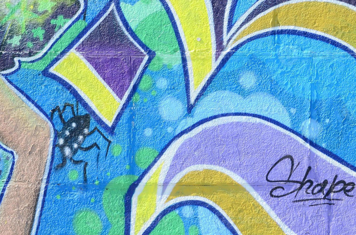 Fragment of graffiti drawings. The old wall decorated with paint stains in the style of street art culture. Colored background texture in cold tones photo