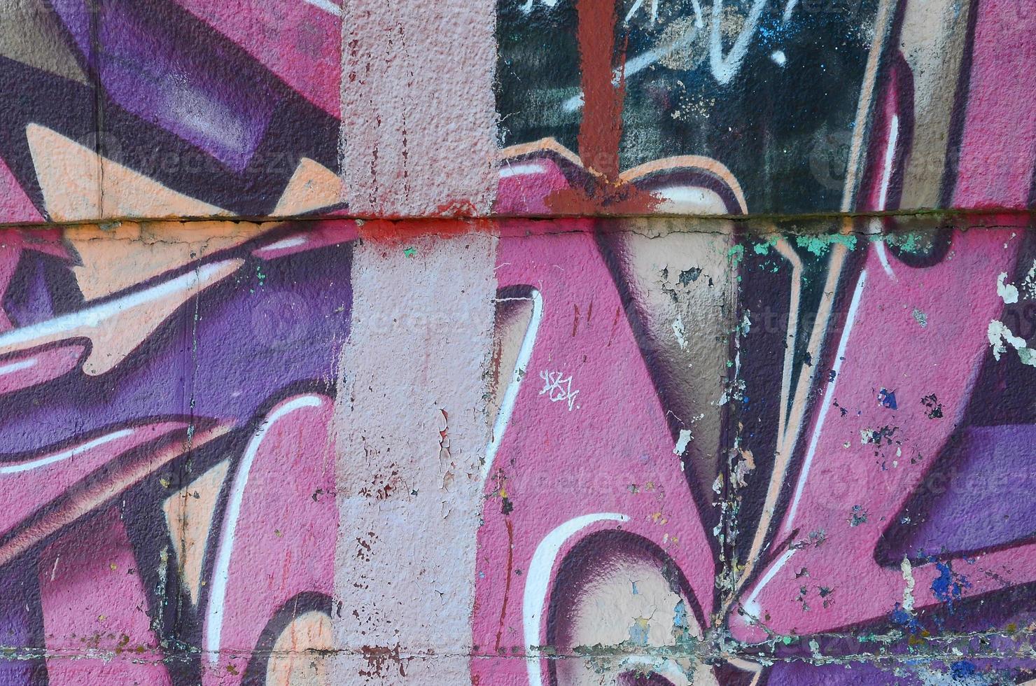 Fragment of graffiti drawings. The old wall decorated with paint stains in the style of street art culture. Colored background texture in purple tones photo
