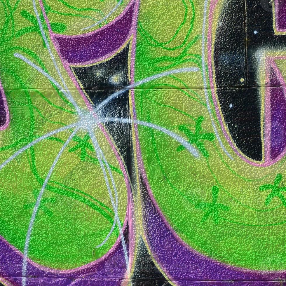 Fragment of graffiti drawings. The old wall decorated with paint stains in the style of street art culture. Colored background texture in green tones photo