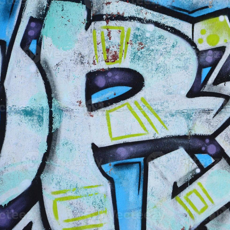 Fragment of graffiti drawings. The old wall decorated with paint stains in the style of street art culture. Colored background texture in cold tones photo