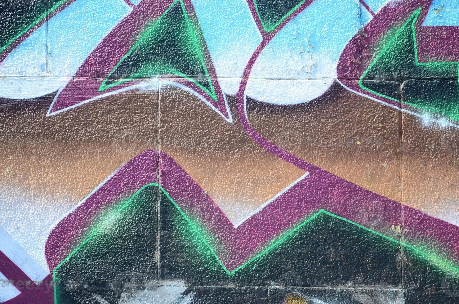 fragmento de dibujos de graffiti. la antigua muralla decorada con manchas de pintura al estilo de la cultura del arte callejero. textura de fondo coloreada en tonos fríos foto