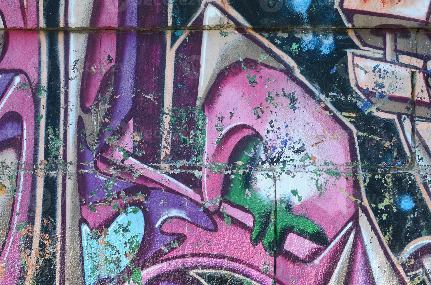 Fragment of graffiti drawings. The old wall decorated with paint stains in the style of street art culture. Colored background texture in purple tones photo