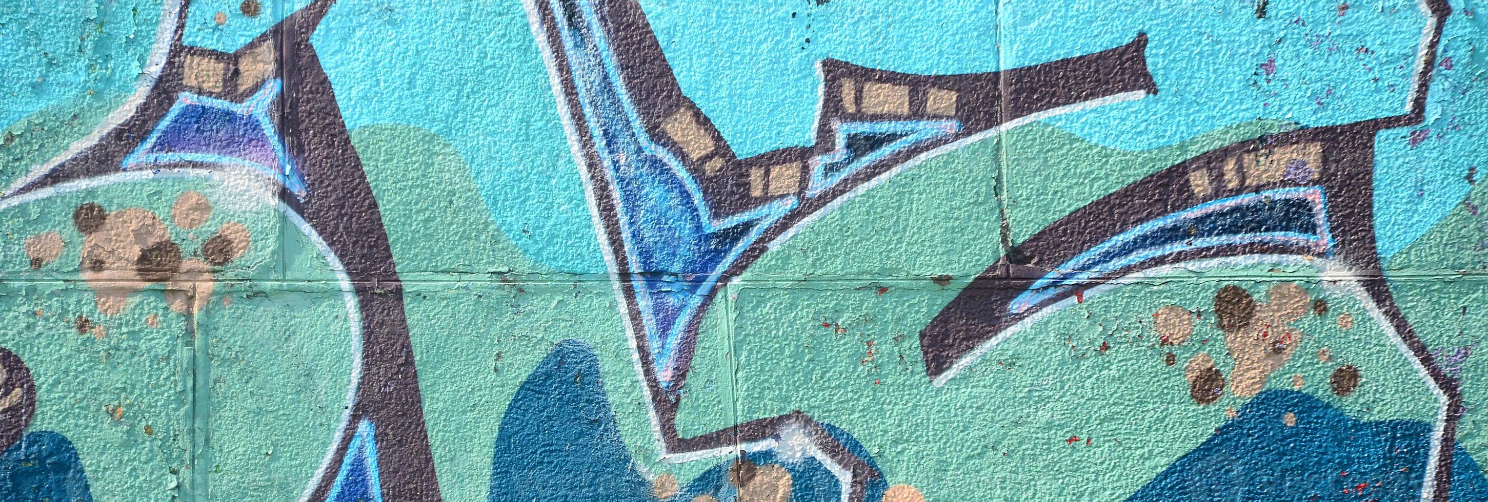 Fragment of graffiti drawings. The old wall decorated with paint stains in the style of street art culture. Colored background texture in cold tones photo