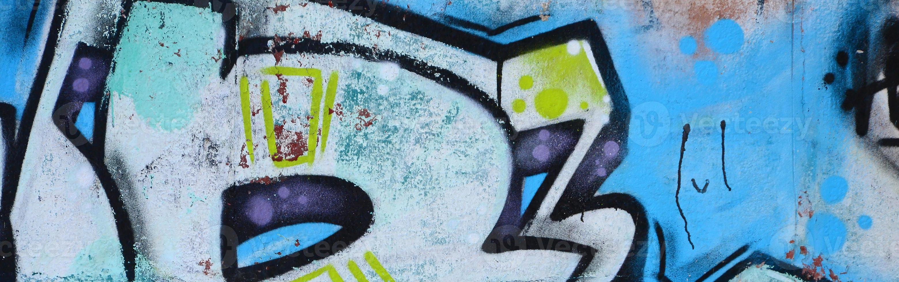 fragmento de dibujos de graffiti. la antigua muralla decorada con manchas de pintura al estilo de la cultura del arte callejero. textura de fondo coloreada en tonos fríos foto