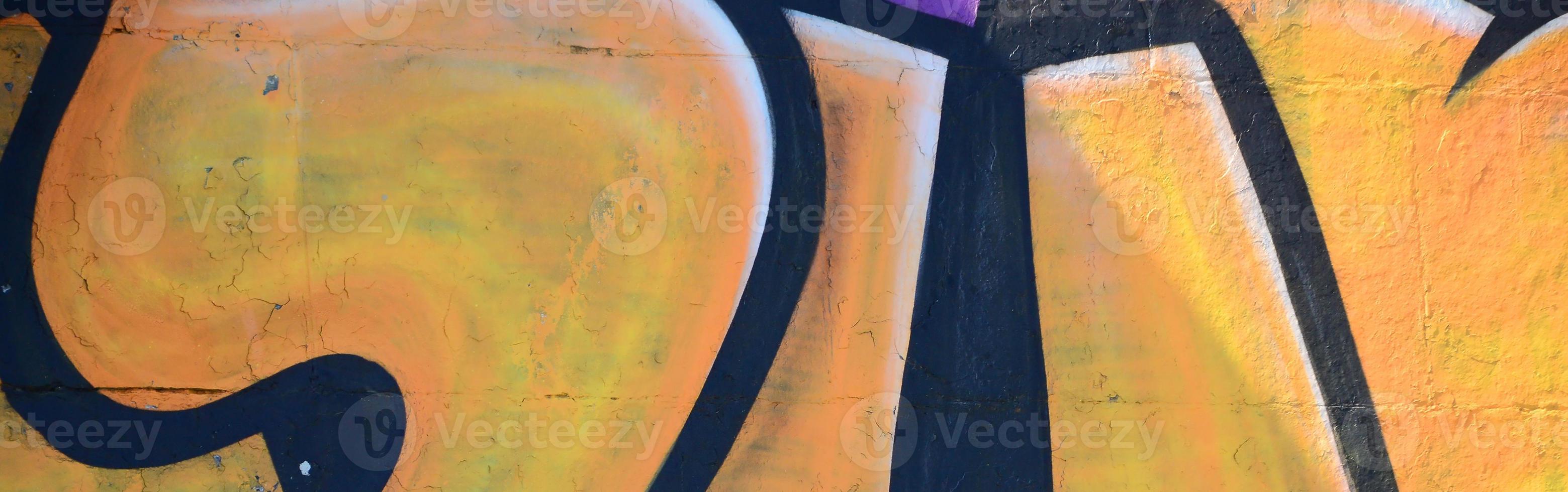 Fragment of graffiti drawings. The old wall decorated with paint stains in the style of street art culture. Colored background texture in warm tones photo
