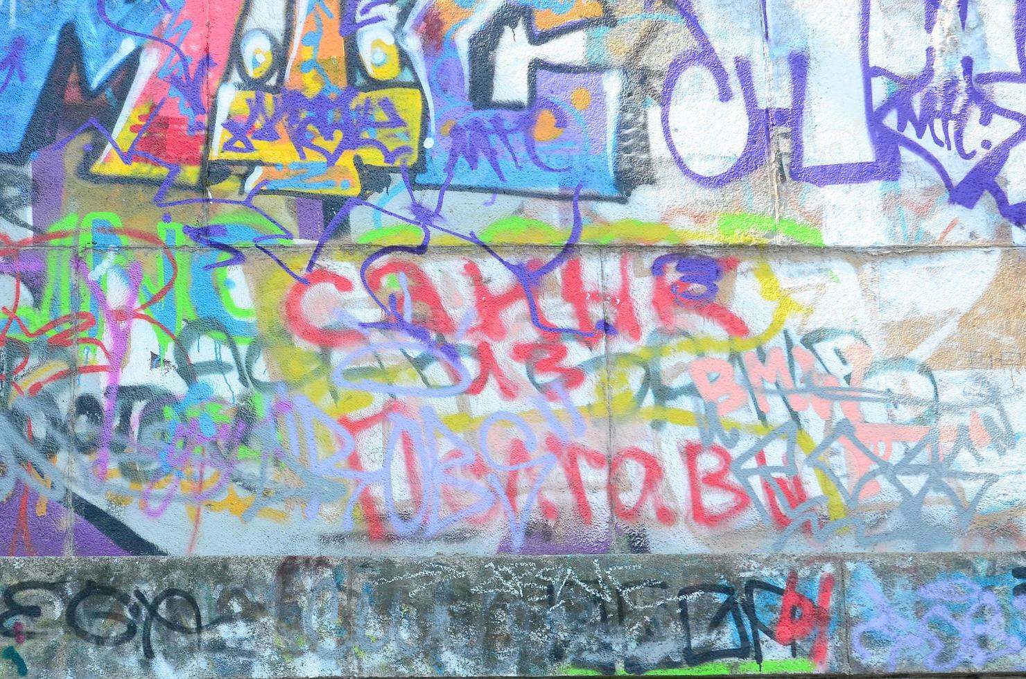 Fragment of graffiti tags. The old wall is spoiled with paint stains in the style of street art culture photo