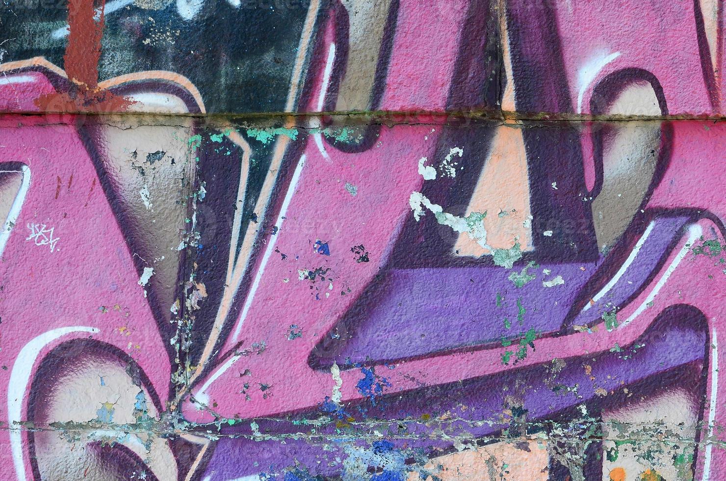 Fragment of graffiti drawings. The old wall decorated with paint stains in the style of street art culture. Colored background texture in purple tones photo