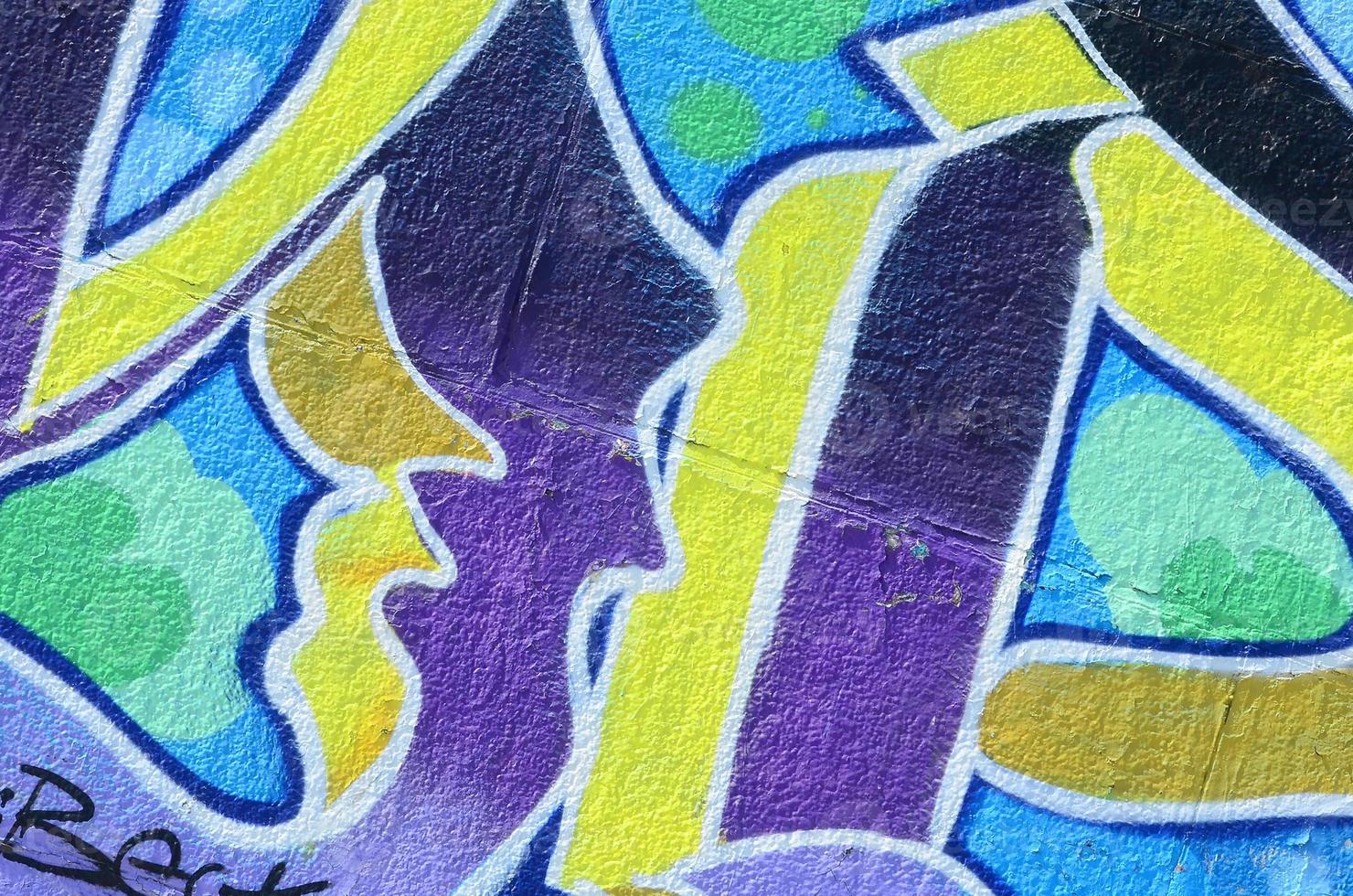 fragmento de dibujos de graffiti. la antigua muralla decorada con manchas de pintura al estilo de la cultura del arte callejero. textura de fondo coloreada en tonos fríos foto