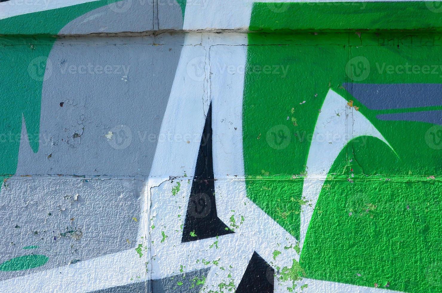 Fragment of graffiti drawings. The old wall decorated with paint stains in the style of street art culture. Colored background texture in green tones photo