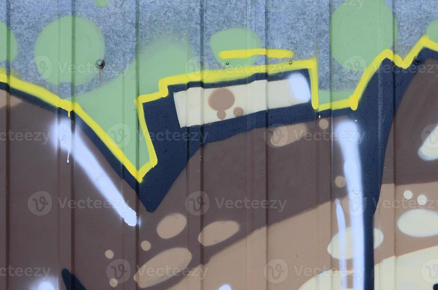 Fragment of graffiti drawings. The old wall decorated with paint stains in the style of street art culture. Colored background texture photo