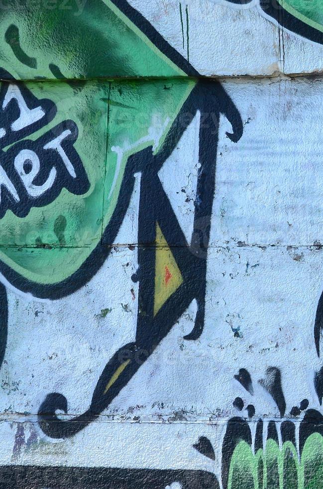 Fragment of graffiti drawings. The old wall decorated with paint stains in the style of street art culture. Colored background texture in green tones photo