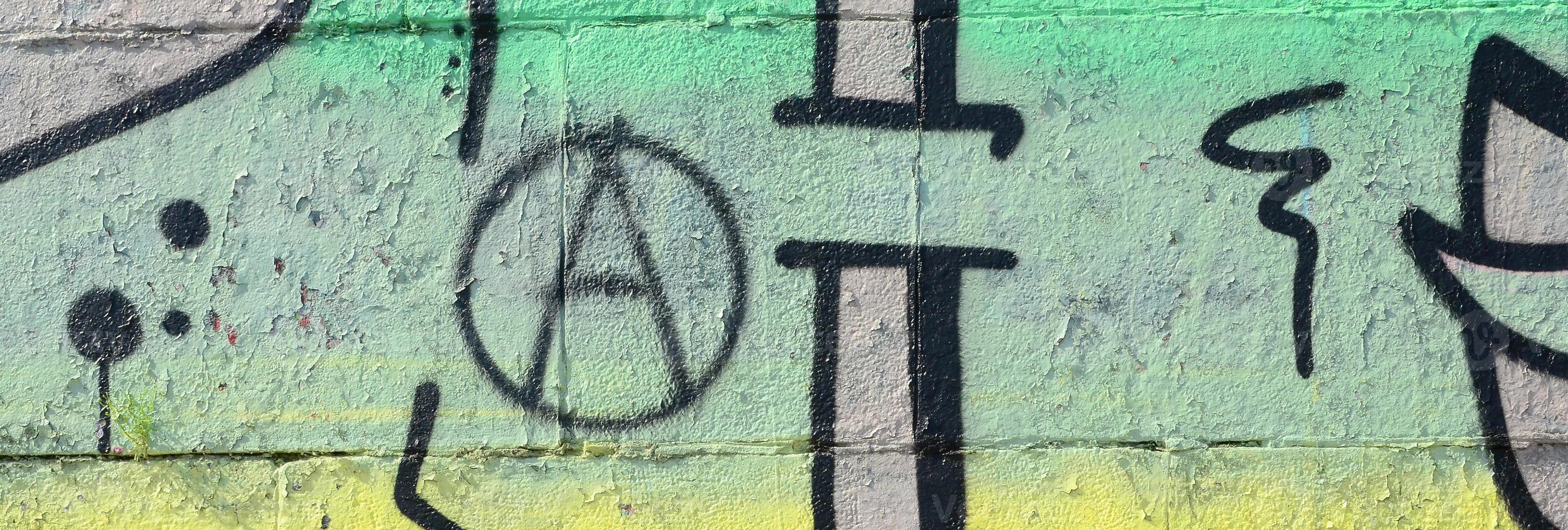 Fragment of graffiti drawings. The old wall decorated with paint stains in the style of street art culture. Colored background texture in green tones photo