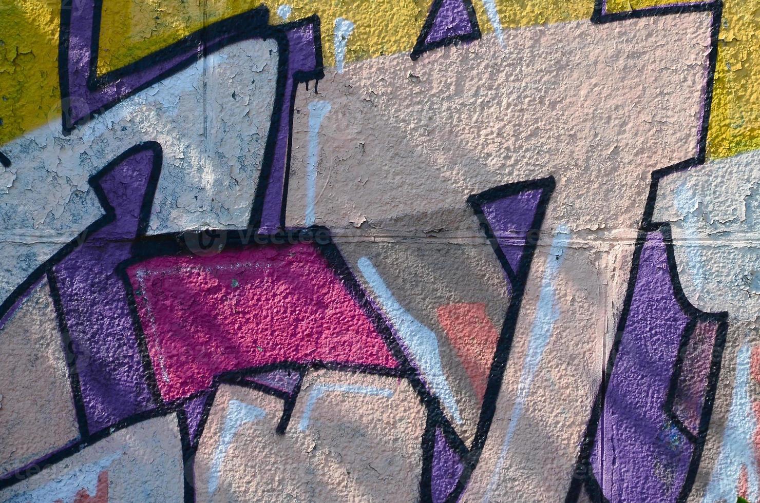 Fragment of graffiti drawings. The old wall decorated with paint stains in the style of street art culture. Colored background texture in warm tones photo