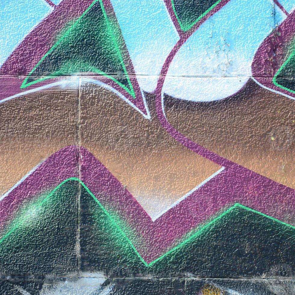 fragmento de dibujos de graffiti. la antigua muralla decorada con manchas de pintura al estilo de la cultura del arte callejero. textura de fondo coloreada en tonos fríos foto