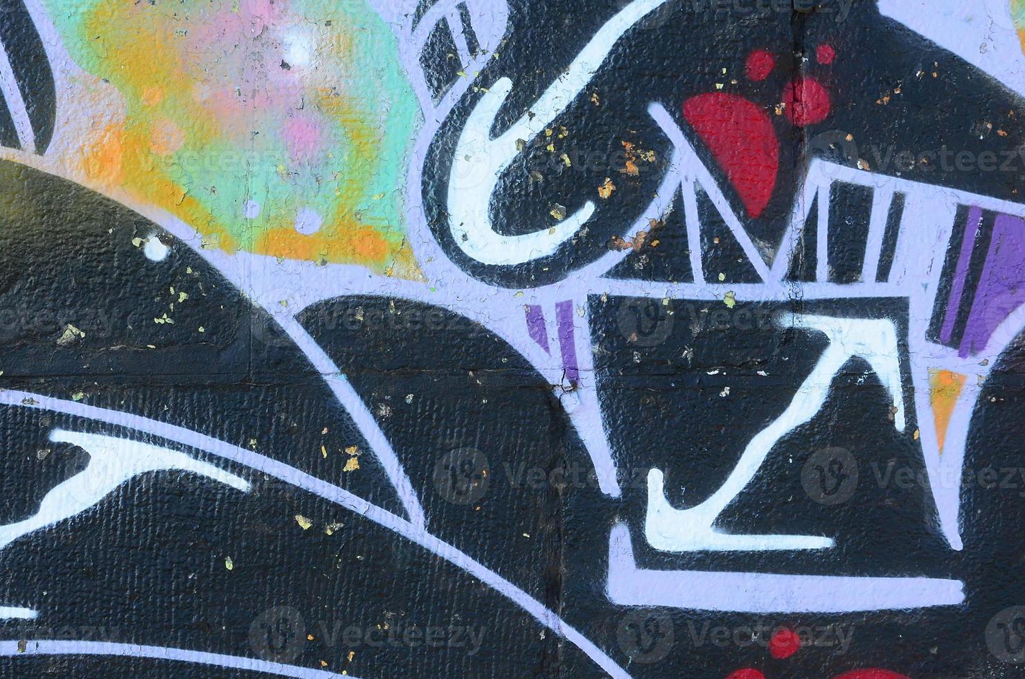 Fragment of graffiti drawings. The old wall decorated with paint stains in the style of street art culture. Colored background texture photo
