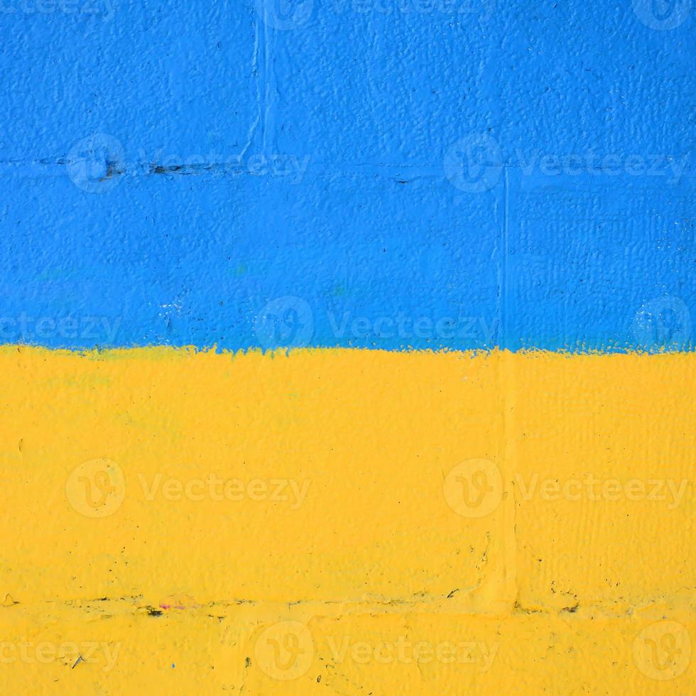 Fragment of graffiti drawings. The old wall decorated with paint stains in the style of street art culture. Ukrainian flag photo