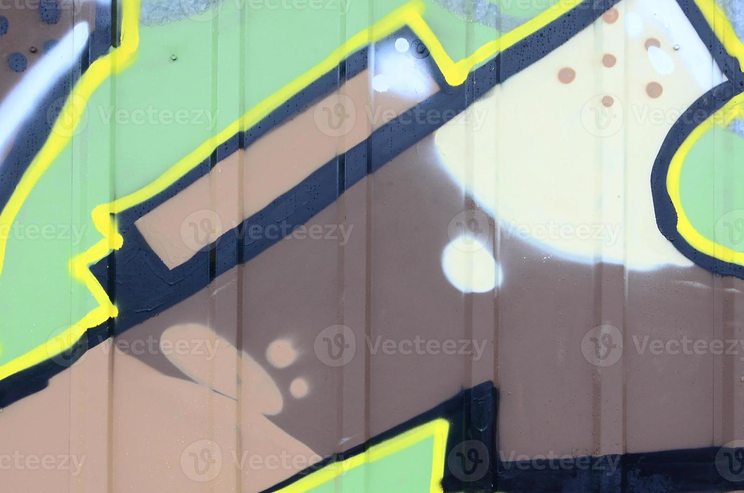 Fragment of graffiti drawings. The old wall decorated with paint stains in the style of street art culture. Colored background texture photo