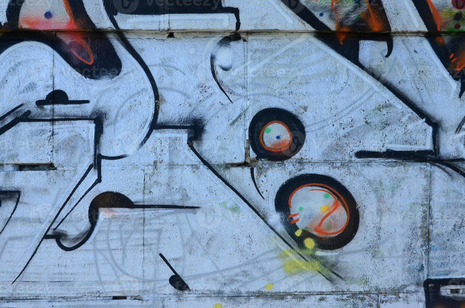 Fragment of graffiti drawings. The old wall decorated with paint stains in the style of street art culture. Colored background texture photo