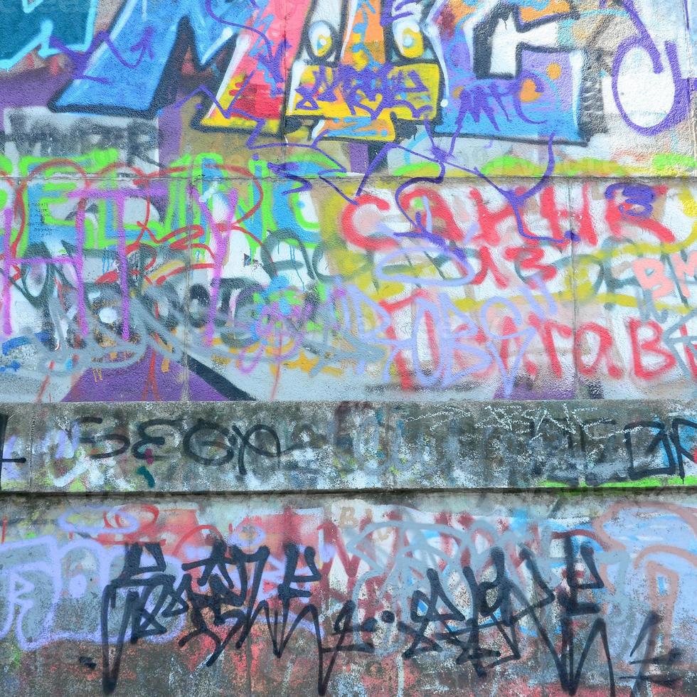 Fragment of graffiti tags. The old wall is spoiled with paint stains in the style of street art culture photo