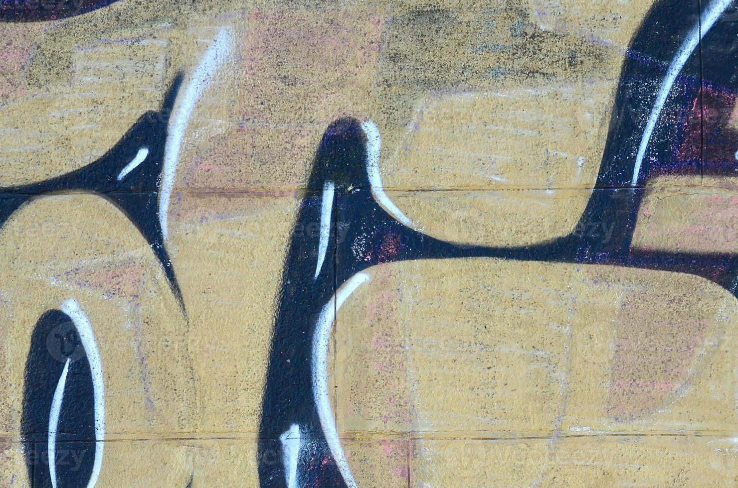 Fragment of graffiti drawings. The old wall decorated with paint stains in the style of street art culture. Colored background texture in warm tones photo