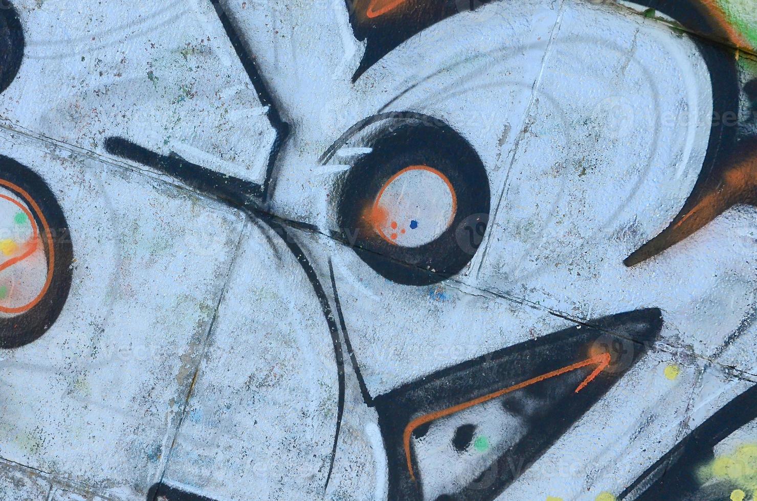 Fragment of graffiti drawings. The old wall decorated with paint stains in the style of street art culture. Colored background texture photo