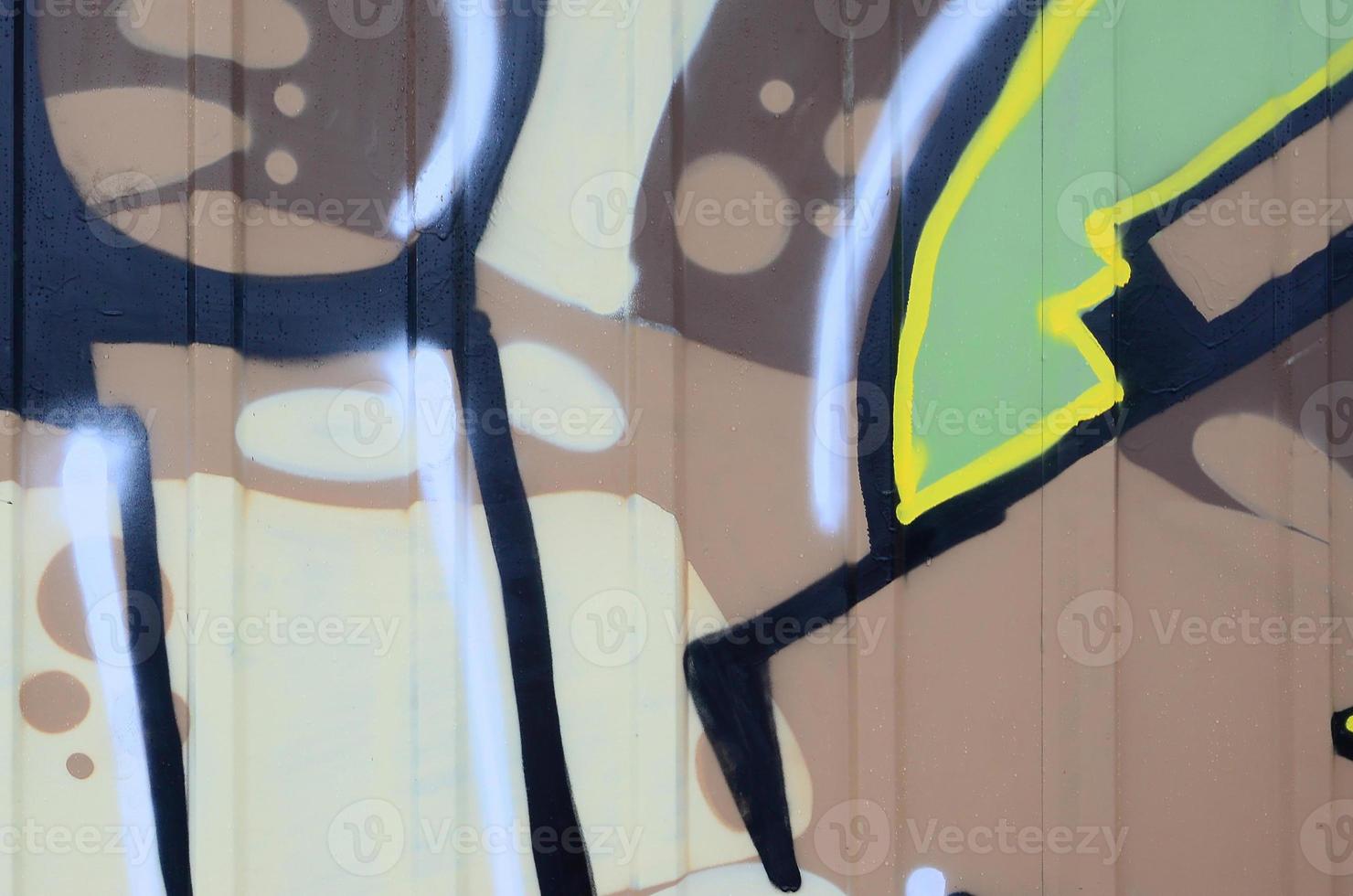 Fragment of graffiti drawings. The old wall decorated with paint stains in the style of street art culture. Colored background texture photo