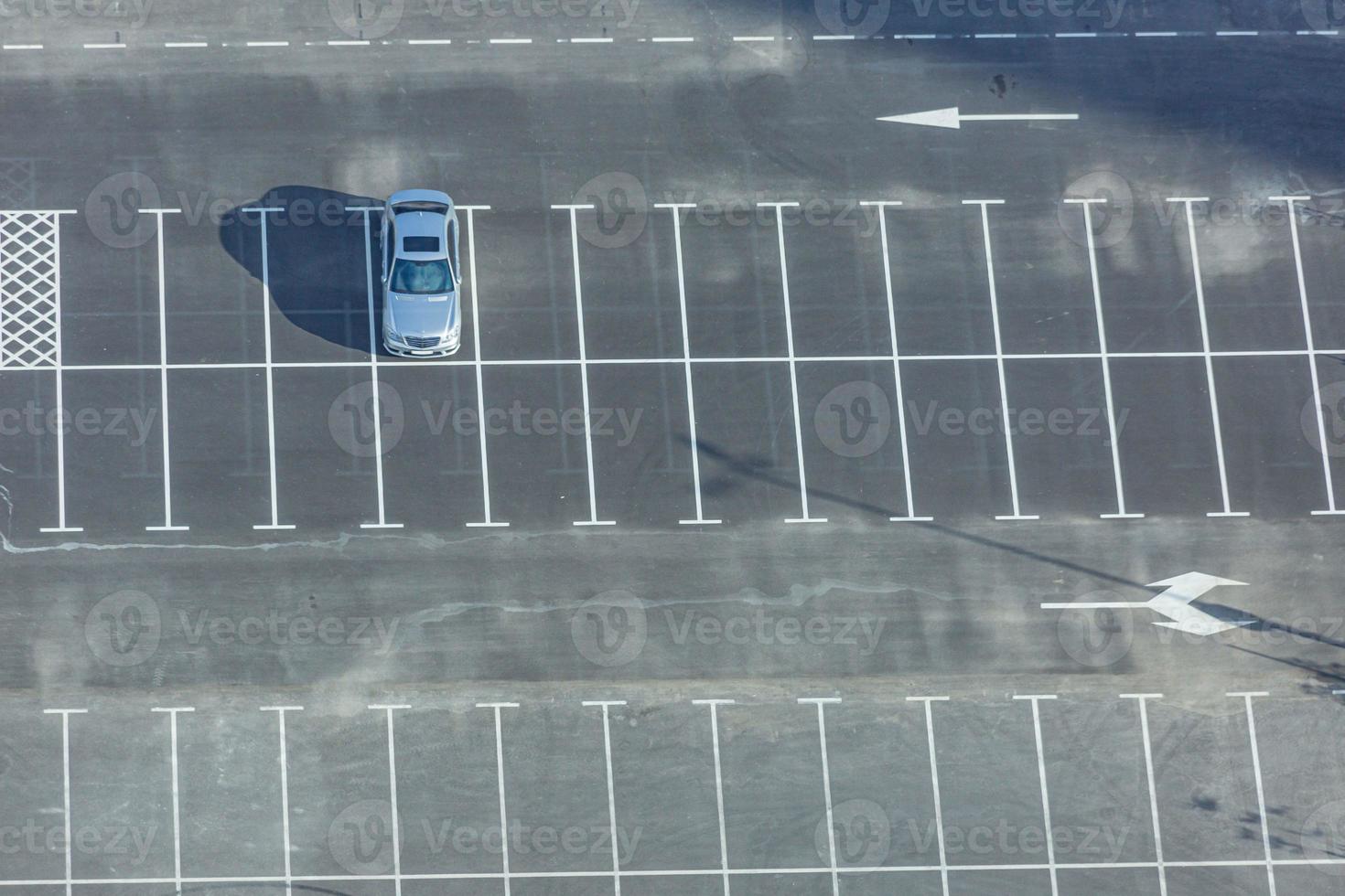 vista aérea de la plataforma de aparcamiento vacía con un coche solitario durante el día foto