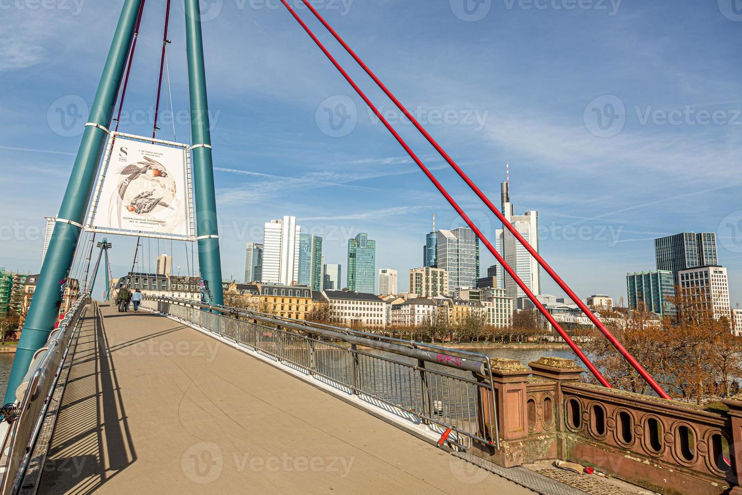 Picture of pedestrian bridge Holbeinsteg in Frankfurt over the river Main and skyline under blue sky and sunshine photo