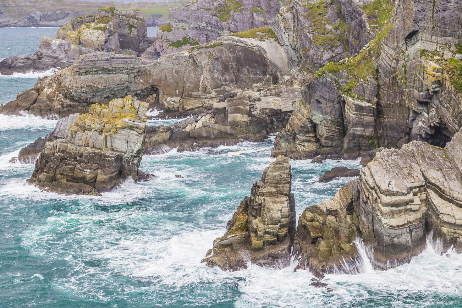 Rough cliff line at Mizen head lighthouse in southern west Ireland during daytime photo